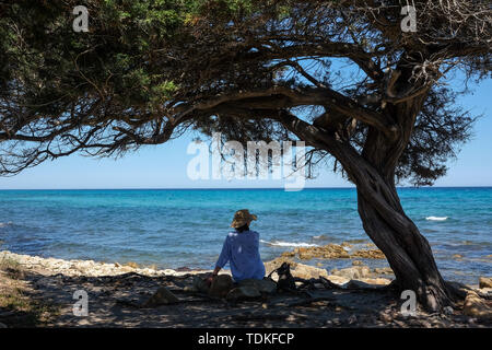 Nuoro, Italie. Le 05 juin, 2019. Une femme est assise sous un arbre sur une plage dans le Parc National di Bidderosa dans le golfe d'Orosei. Credit : Jens Kalaene Zentralbild-/dpa/ZB/dpa/Alamy Live News Banque D'Images