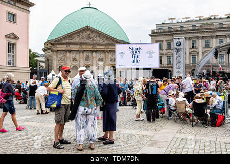 Berlin. Allemagne, 16 juin 2019. Les foules se rassemblent à la Bebelplatz en face de la cathédrale d'Hedwige dans Unter den Linden pour le Staatsoper gratuit annuel für Alle Open Air Concert dirigé par Daniel Barenboim. L'Orchestre a donné la musique de Johannes Brahms et Felix Mendelssohn Bartholdy sur une étape temporaire. La rue a été fermée à la circulation et les Berlinois et les touristes affluent vers la zone de concert avec des chaises pliantes et des paniers de pique-nique. Credit : Eden Breitz/Alamy Banque D'Images