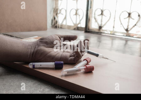 Toxicomane part avec la seringue sur le sol avec un tubes de médicaments Banque D'Images