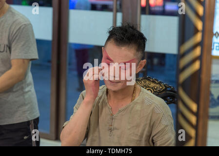 L'acteur chinois traditionnel s'applique du maquillage avant un spectacle dans un théâtre chinois. Photographié à Chengdu, Sichuan, Chine Banque D'Images