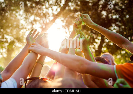 Un groupe de jeunes indiens sur les peintures pierres Holi festival de couleurs. Close up of hands raised up Banque D'Images