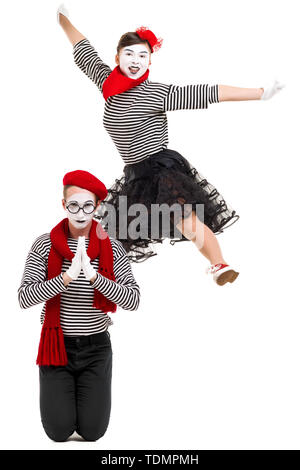 Smiling mimes en chemises à rayures. surpris l'homme et femme saut isolé sur fond blanc Banque D'Images