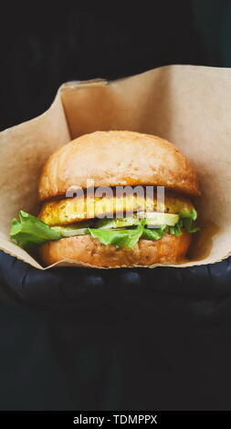 Snacks végétaliens - burger avec étiquette de texte dans les mains Banque D'Images