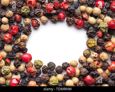 Poivre blanc avec fond mixte de l'espace de copie dans le centre. Arrière-plan de l'alimentation avec des grains de poivre. Poivre de différentes couleurs sur fond blanc, vue de dessus ou de mise à plat Banque D'Images