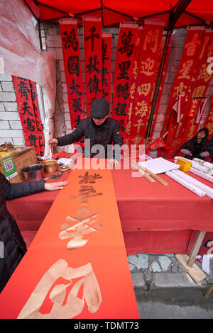 Shanghai, Chine - février 10,2018 : un calligraphe est écrit Couplets Festival du printemps pour les gens c'est le plus commun et important personnalisé si cel. Banque D'Images