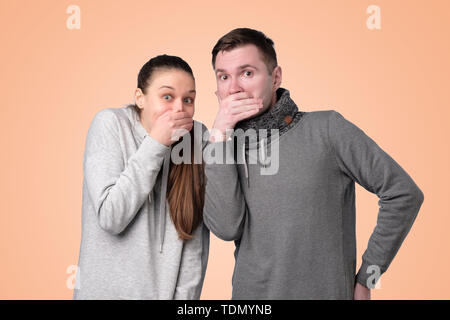 L'homme et la femme en riant et en couvrant la bouche avec la main Banque D'Images