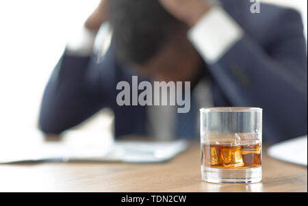 Les entreprises africaines désespérées la souffrance au travail, avec verre de whisky Banque D'Images