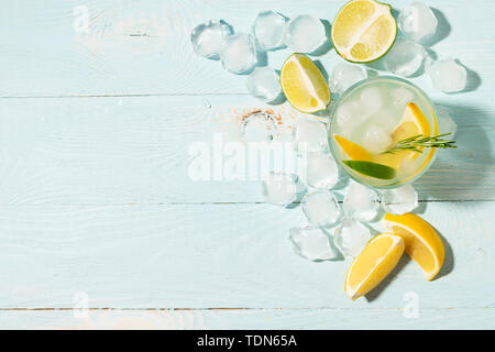Un verre de limonade citron et lime en verres transparents fond bleu plein soleil. Cocktail d'été ou mojito.