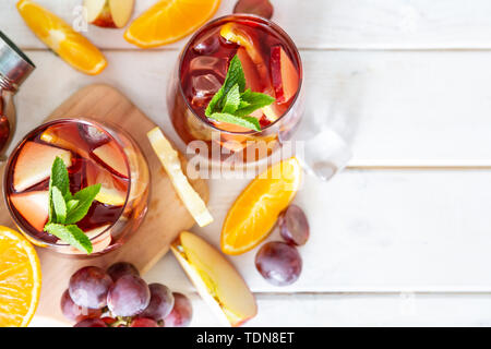 La sangria et les ingrédients dans les verres sur fond de bois Banque D'Images