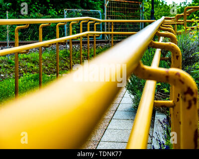 Voir sur une balustrade jaune rouillé d'un trottoir sur une journée ensoleillée. Banque D'Images