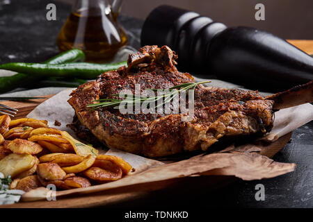 Tomahawk steak avec des légumes et un couteau sur la table. La viande grillée, légumes grillés et légumes frais sur la table. Banque D'Images