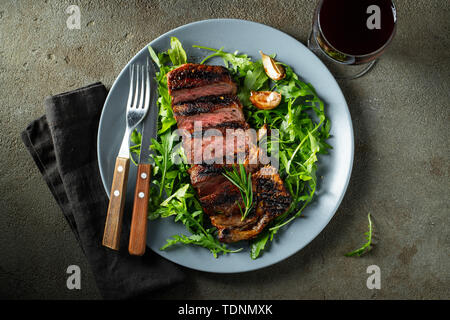 Ribeye Steak de boeuf grillé avec du vin rouge, les herbes et épices. Vue d'en haut. Mise à plat. Banque D'Images