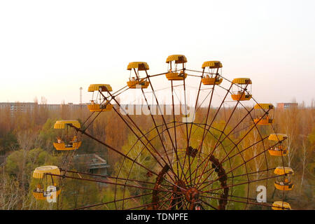 Grande roue de la ville de Pripyat au coucher du soleil. La ville de Pripyat apocalyptique après une explosion nucléaire dans une centrale nucléaire. En carrousel rouillé Banque D'Images