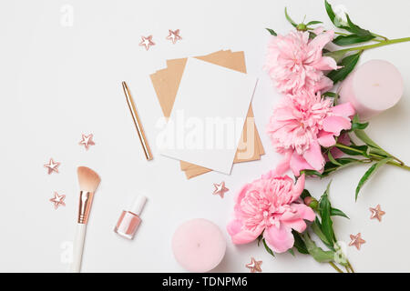La mise en page d'accueil minimaliste carte avec fleurs de pivoines rose, enveloppe pour la couture, la floraison, la mise à plat, vue du dessus Banque D'Images