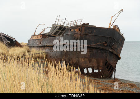 Rusty cargo échoué sur la rive avec des chaînes en la maintenant enfoncée Banque D'Images