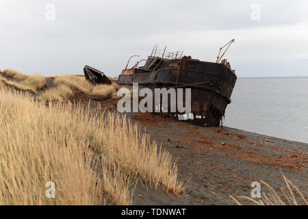 Rusty cargo échoué sur la rive avec des chaînes en la maintenant enfoncée Banque D'Images