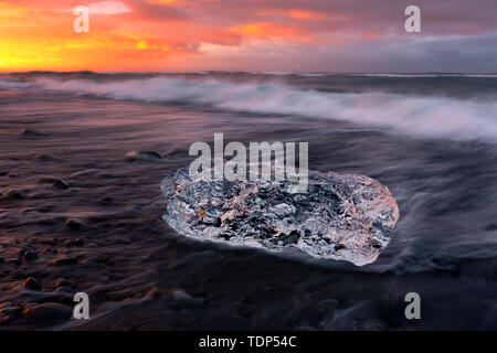 Le voyage vers l'Islande tire à sa fin, et bien que tout le voyage autour de l'île a été achevé, il est vraiment mauvais de ne pas avoir de beau temps sur la glace et de la plage. Afin de saisir le dernier lever de soleil, 750 kilomètres aller-retour de la capitale Reykjavik à 22 heures le jour d'avant, comme vous le souhaitez, un beau lever de soleil sur la plage de glace au sud de Jekussalon le lac Glacier. Banque D'Images