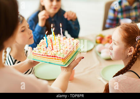 High angle view of mère apportant le gâteau d'anniversaire avec des bougies pour des enfants parti, copy space Banque D'Images