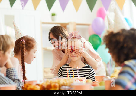 Portrait of happy little girl smearing cake pendant party, copy space Banque D'Images