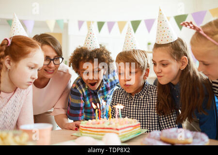 Portrait of happy boy smearing cake pendant la fête entre amis , copy space Banque D'Images