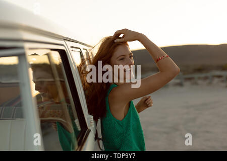 Belle femme appuyée sur le camping-car at beach Banque D'Images