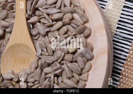 Table ronde en bois avec des graines de tournesol décortiquées et cuillère en bois Banque D'Images