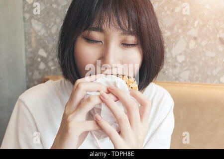 Close-up of girl biting hamburger Banque D'Images
