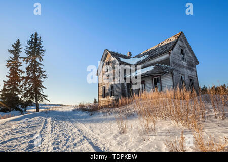 Maison de ferme délabrée au lever du soleil en hiver, près de Winnipeg, Manitoba, Canada Banque D'Images