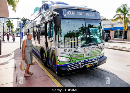 Miami Beach Florida,Washington Avenue,Miami-Dade Metrobus,arrêt,femme femmes,passagers motards,transport de sacs de shopping en plastique,Wai Banque D'Images