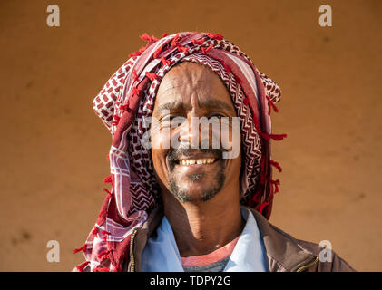 Portrait d'un homme de l'Érythrée en souriant avec un foulard sur la tête, le lundi ; marché de bétail de la région d'Anseba, Keren, Erythrée Banque D'Images