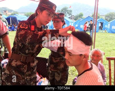 Yibin, province chinoise du Sichuan. 18 Juin, 2019. Un membre du personnel médical de la force de police armée traite un homme blessé à un abri temporaire en ville Shuanghe High School à Changning County de Yibin City, dans le sud-ouest de la province chinoise du Sichuan, le 18 juin 2019. Treize personnes sont mortes et 199 ont été blessés après un séisme de magnitude 6,0 a frappé le sud-ouest de la province chinoise du Sichuan à 10:55 h le lundi, le ministère de la gestion des urgences a déclaré mardi. Crédit : Li Huashi/Xinhua/Alamy Live News Banque D'Images