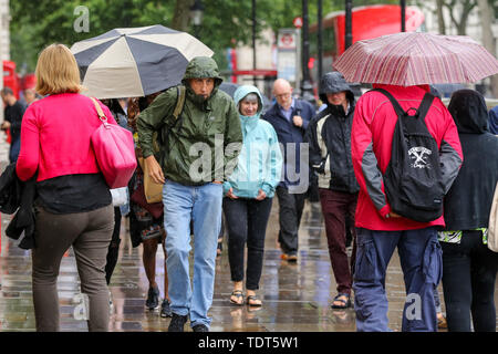 Westminster, London, UK 18 juin 2019 - Les touristes à l'abri de la pluie dans la région de Westminster. Le Met Office a émis une alerte météo jaune pour Londres comme les pluies torrentielles, la grêle et la foudre est prévue. Credit : Dinendra Haria/Alamy Live News Banque D'Images