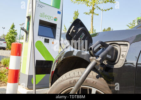 Hambourg, Allemagne. 19 Juin, 2019. Un Jaguar J-Pace est debout à un ultra-rapide avec la station de charge jusqu'à 350 kW de puissance de charge pendant un communiqué de nomination. L'opérateur de solutions de chargement 'Allego' a ouvert son premier emplacement de charge à haute performance pour les véhicules électriques en Allemagne sur le parking de la jardinerie 'Garten von Ehren' dans Harburg. Le temps de charge à cette colonne est à moins de 5 minutes pour 100 km de portée. Credit : Georg Wendt/dpa/Alamy Live News Banque D'Images