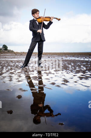 Viktor Seifert, 12 ans, de St Mary's Music School d'Édimbourg, joue l'Orca Driftwood Viola par la mer à Musselburgh, East Lothian, en avance sur sa performance à la Royal Academy of Music de Londres le 18 juillet 2019, dans la 'Dance pour la mer" événement qui appuie le travail de la Marine Conservation Society. Banque D'Images