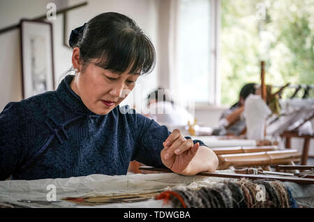 (190619) -- SHANGHAI, le 19 juin 2019 (Xinhua) -- Yao Huifen rend la broderie à son atelier de Zhenhu Ville de Suzhou, Province de Jiangsu Chine orientale, le 11 juin 2019. La broderie de Suzhou, l'une des quatre plus célèbres broderies en Chine, est originaire de Suzhou et a une histoire de plus de 2 000 ans. Connu pour son élégant motif, conception artistique, de couture fine et variée de suture, elle est inscrite comme patrimoine culturel immatériel national de Chine en 2006. Yao Huifen représentant, héritière de la plaisance, est né à Shanghai en 1967 dans une famille de broderie. Influencé par ses grands-parents et p Banque D'Images