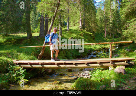 Femme wanderer sur pont de bois dans la vallée de l'Aelpeletal, Autriche, Tyrol, Alpes, Gaishorn Allgaeu Banque D'Images