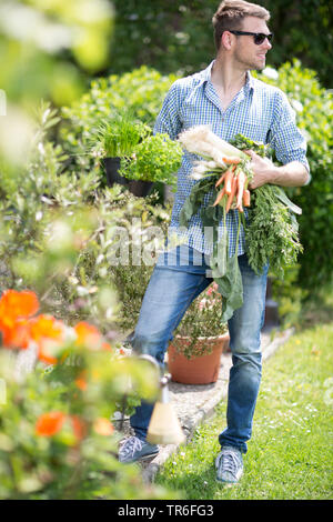 Jeune homme avec les légumes de son propre jardin, Allemagne Banque D'Images