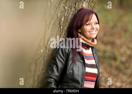 Femme s'appuie sur un arbre Banque D'Images