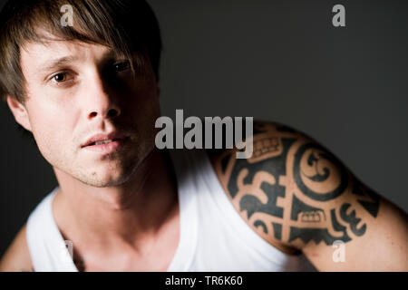 Tattooed man en maillot de corps blanc Banque D'Images