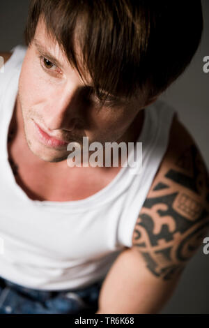 Tattooed man en maillot de corps blanc Banque D'Images