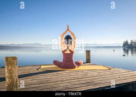 Woman doing yoga des exercices dans un lac, de l'Allemagne, la Bavière Banque D'Images