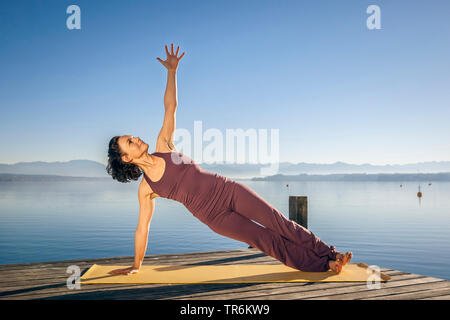 Woman doing yoga des exercices dans un lac, de l'Allemagne, la Bavière Banque D'Images