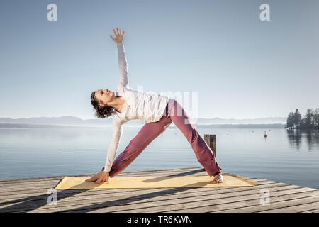 Woman doing yoga des exercices dans un lac, de l'Allemagne, la Bavière Banque D'Images