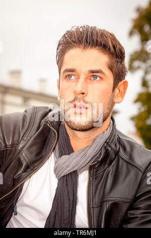 Jeune homme séduisant avec veste en cuir dans la ville, Allemagne Banque D'Images