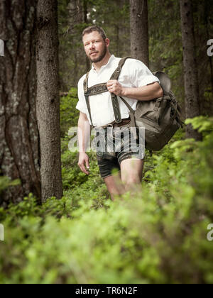 Jeune homme avec lederhose bavaroise en randonnée dans une forêt, en Allemagne, en Bavière Banque D'Images