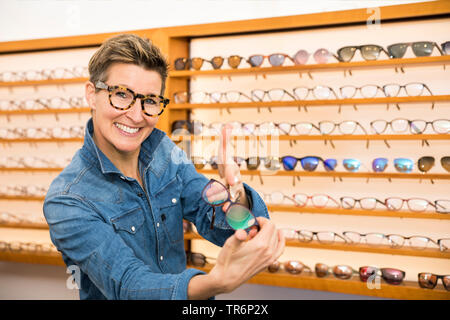 Femme dans un magasin de lunettes, Allemagne Banque D'Images