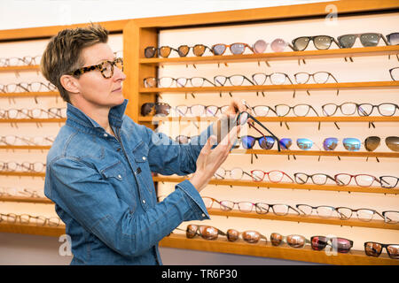 Femme dans un magasin de lunettes, Allemagne Banque D'Images