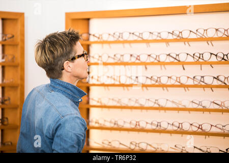 Femme dans un magasin de lunettes, Allemagne Banque D'Images