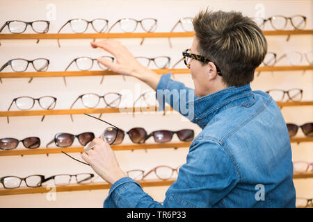 Femme dans un magasin de lunettes, Allemagne Banque D'Images