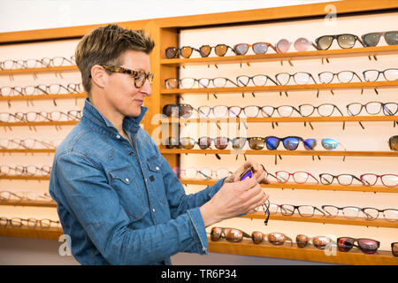 Femme dans un magasin de lunettes, Allemagne Banque D'Images